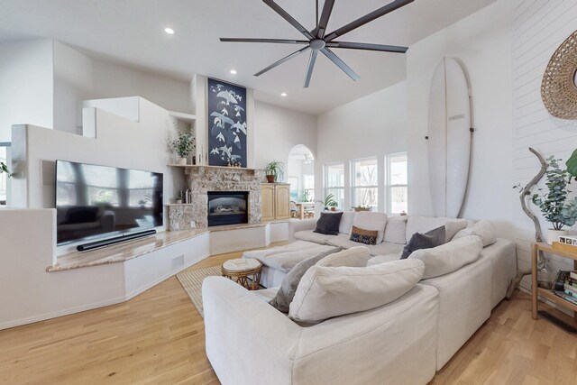 122 Martha Ct, Corrales, NM 87048 - living area with light wood-style flooring, a towering ceiling, and a glass covered fireplace