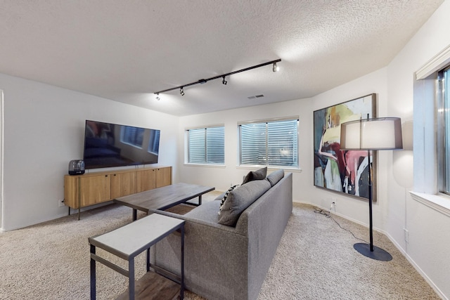 122 Martha Ct, Corrales, NM 87048 - carpeted living area featuring track lighting, a textured ceiling, visible vents, and plenty of natural light