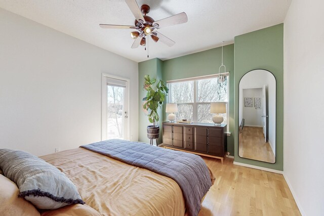 122 Martha Ct, Corrales, NM 87048 - bedroom with arched walkways, light wood finished floors, baseboards, and ceiling fan