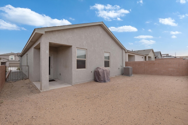 back of property with a patio, central AC unit, stucco siding, and a fenced backyard