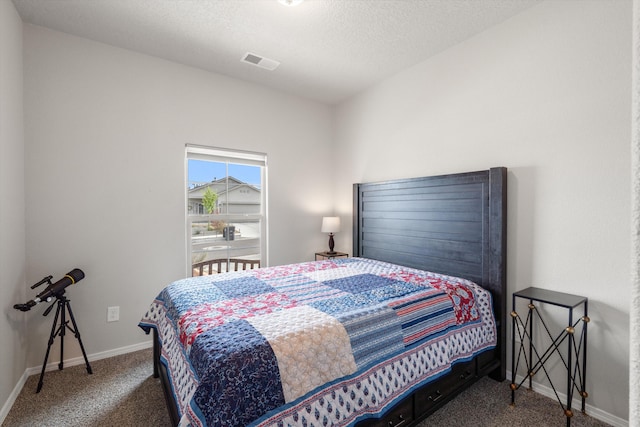 bedroom featuring visible vents, carpet flooring, baseboards, and a textured ceiling