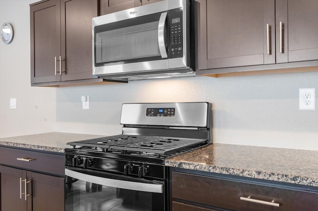 kitchen with dark countertops, dark brown cabinetry, and stainless steel appliances