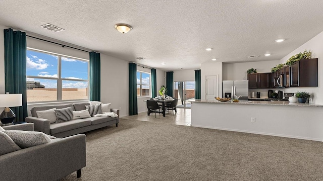 living room with visible vents, recessed lighting, a textured ceiling, and light colored carpet