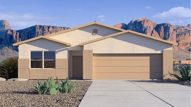 contemporary house with a garage, a mountain view, stucco siding, and concrete driveway