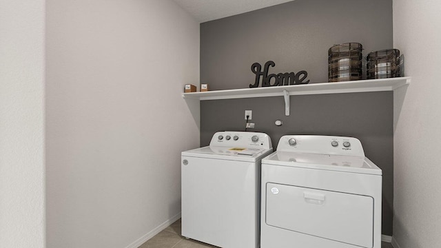 laundry room featuring light tile patterned floors, baseboards, laundry area, and washer and dryer