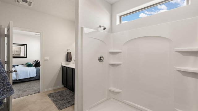 ensuite bathroom with visible vents, tile patterned flooring, vanity, a shower, and ensuite bathroom