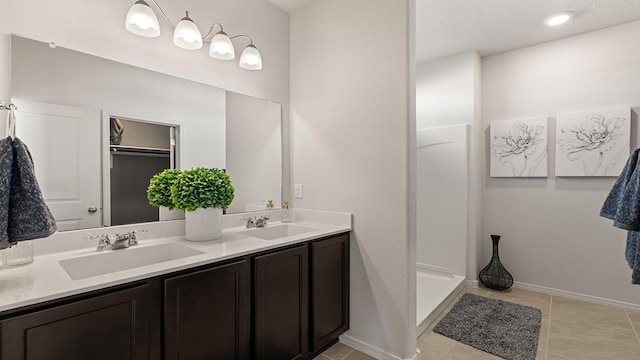 bathroom with double vanity, a sink, and tile patterned flooring