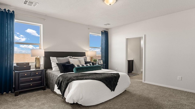 bedroom featuring multiple windows, light carpet, a textured ceiling, and visible vents