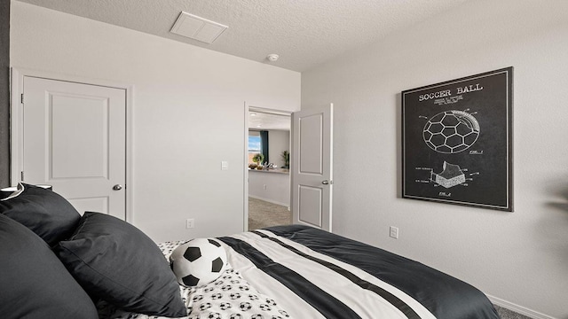 bedroom featuring visible vents, carpet flooring, baseboards, and a textured ceiling