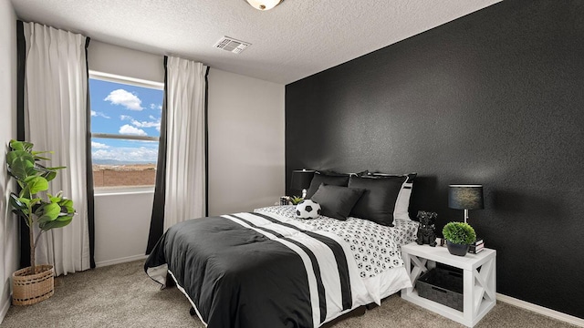 carpeted bedroom featuring visible vents, a textured ceiling, and baseboards