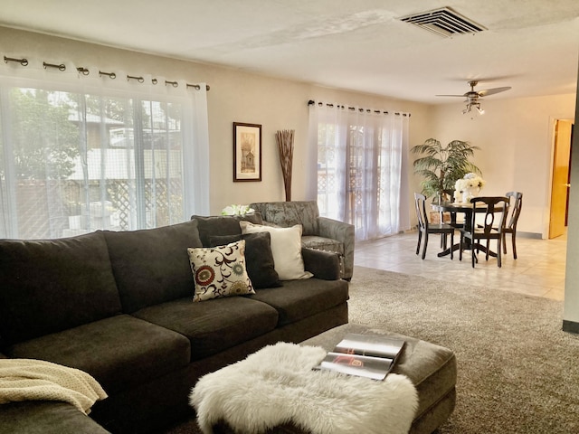 living room featuring light tile patterned floors, visible vents, and a ceiling fan