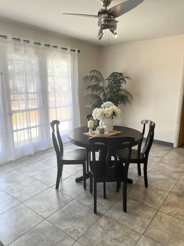 dining space with ceiling fan and light tile patterned flooring
