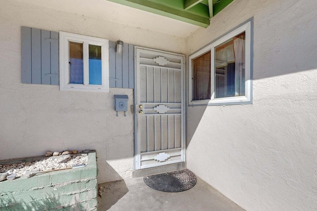 entrance to property featuring stucco siding