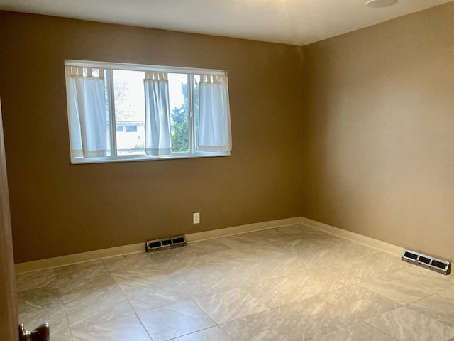 unfurnished room featuring baseboards and visible vents