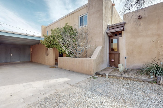 1005 Guadalupe Del Prado St NW, Albuquerque, NM 87107 - view of property exterior with stucco siding and an attached carport
