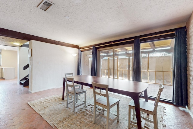 1005 Guadalupe Del Prado St NW, Albuquerque, NM 87107 - dining area with brick floor, a textured ceiling, and visible vents