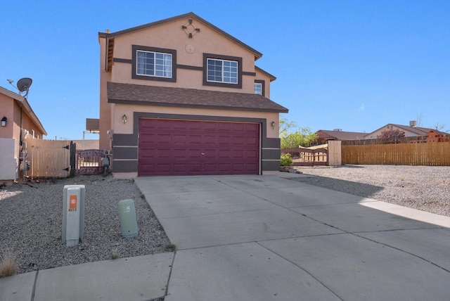 traditional-style house featuring stucco siding, fence, a gate, an attached garage, and concrete driveway