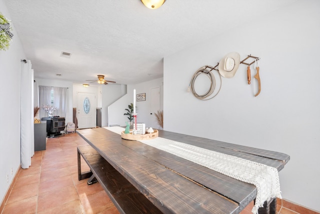 dining room with visible vents, a textured ceiling, light tile patterned flooring, and ceiling fan