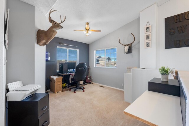 office area featuring ceiling fan, vaulted ceiling, light carpet, and baseboards