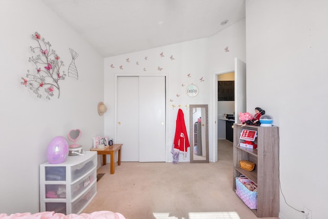 carpeted bedroom with a closet and lofted ceiling