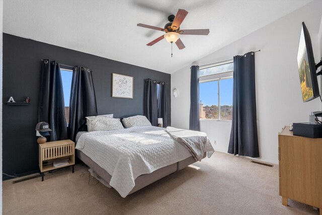 bedroom featuring light carpet, visible vents, ceiling fan, and vaulted ceiling