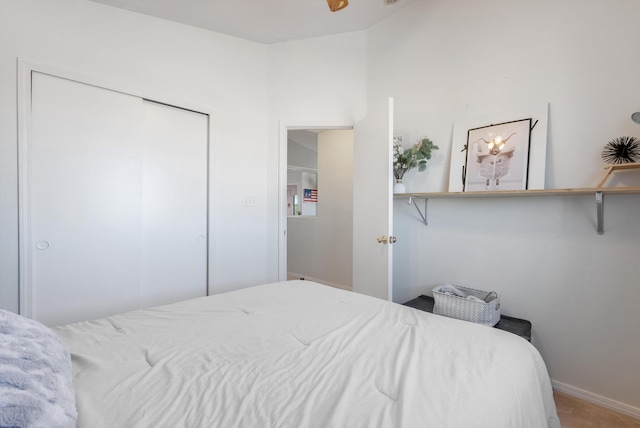 carpeted bedroom with a closet and baseboards