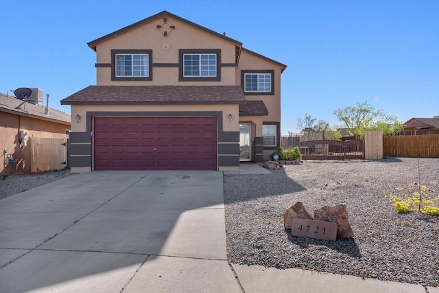 traditional-style house featuring stucco siding, fence, a gate, an attached garage, and concrete driveway