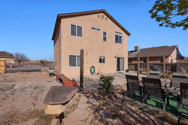 back of house with a patio area, a fenced backyard, and stucco siding