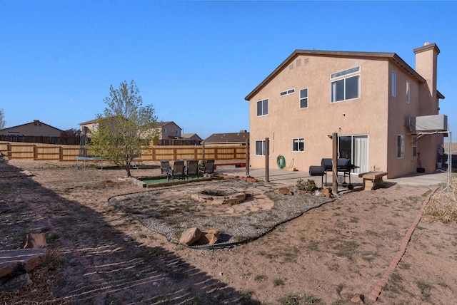 back of house with a patio, a fenced backyard, a chimney, and stucco siding
