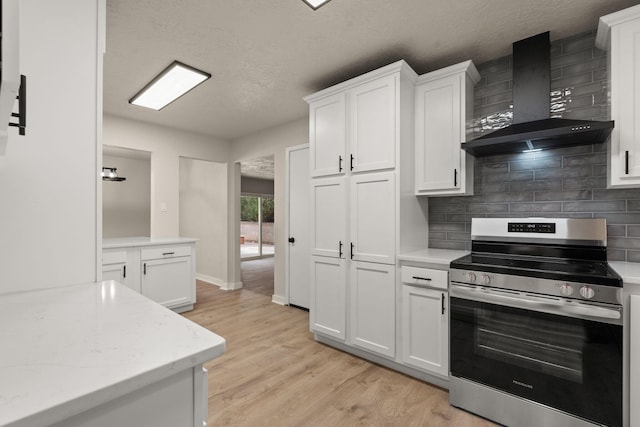 2908 Pennsylvania St NE, Albuquerque, NM 87110 - kitchen featuring wall chimney range hood, electric range, tasteful backsplash, white cabinetry, and light wood-type flooring