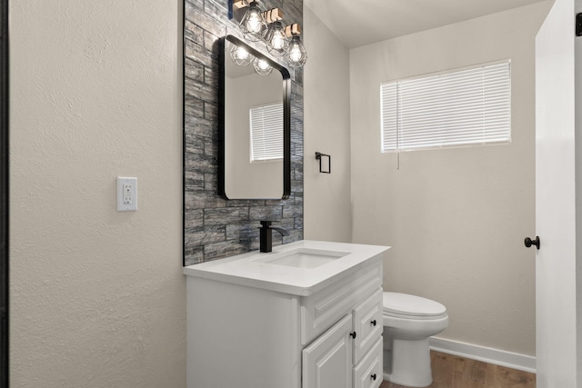 2908 Pennsylvania St NE, Albuquerque, NM 87110 - bathroom with baseboards, wood finished floors, toilet, and vanity