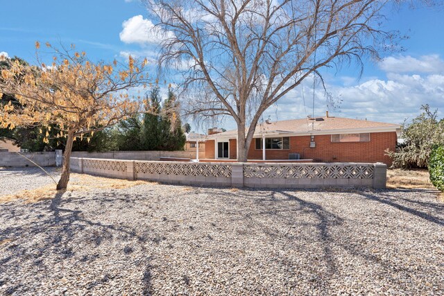 2908 Pennsylvania St NE, Albuquerque, NM 87110 - rear view of property with fence private yard, a chimney, and brick siding