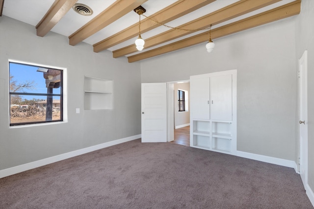 unfurnished bedroom featuring carpet flooring, visible vents, baseboards, and beamed ceiling