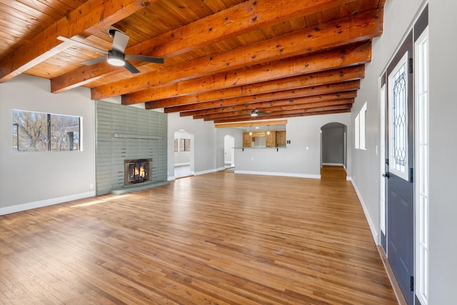 unfurnished living room featuring a fireplace, ceiling fan, arched walkways, wood ceiling, and wood finished floors