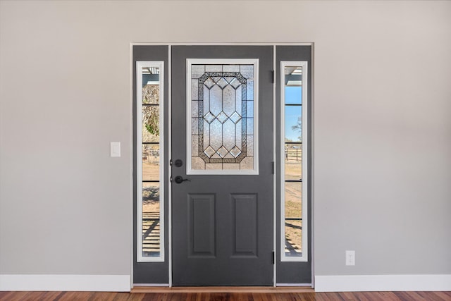 foyer featuring baseboards and wood finished floors