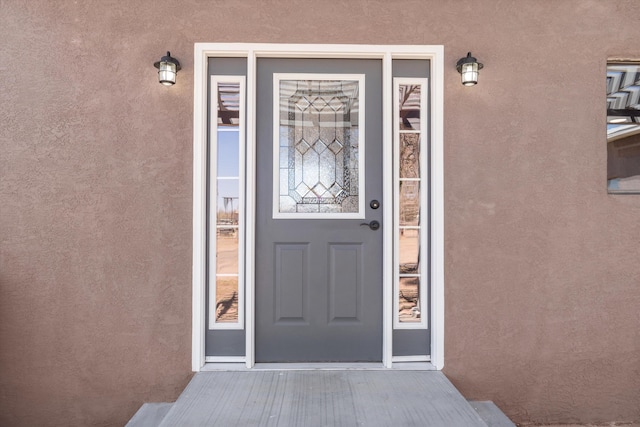 view of exterior entry with stucco siding