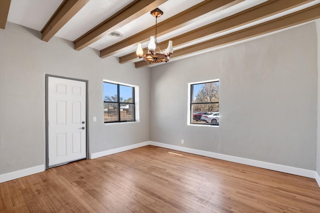 spare room featuring visible vents, light wood finished floors, baseboards, beam ceiling, and a notable chandelier
