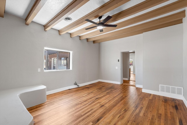 unfurnished room with wood finished floors, ceiling fan, beamed ceiling, and visible vents