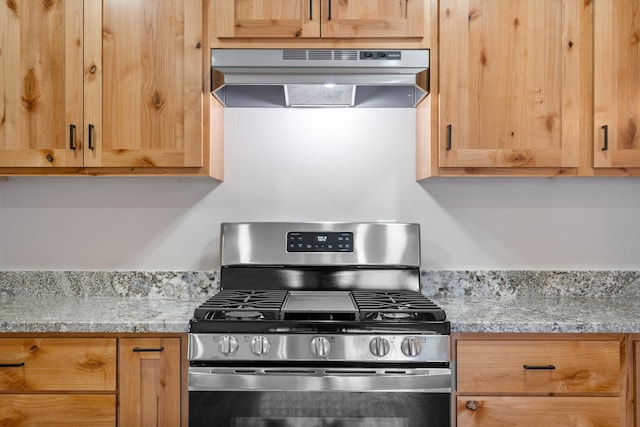 kitchen with light countertops, stainless steel gas range, light brown cabinetry, and under cabinet range hood