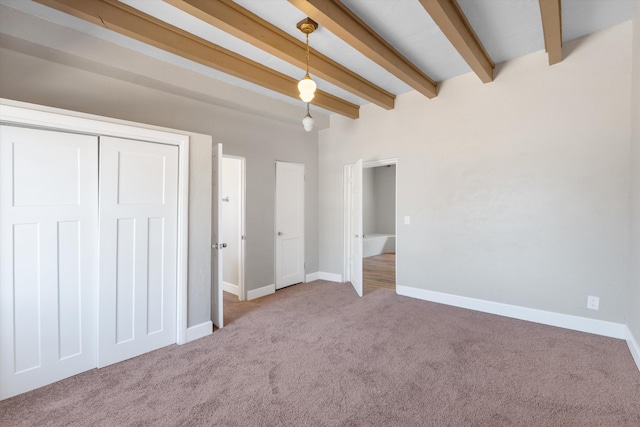 unfurnished bedroom with carpet flooring, baseboards, and beam ceiling