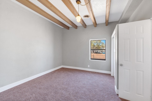 unfurnished room featuring visible vents, baseboards, carpet, and beamed ceiling