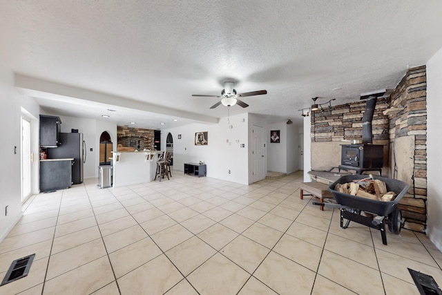 3008 Corona Dr NW, Albuquerque, NM 87120 - living area featuring a ceiling fan, visible vents, arched walkways, a wood stove, and light tile patterned floors