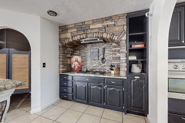 3008 Corona Dr NW, Albuquerque, NM 87120 - bar featuring light tile patterned floors, baseboards, stainless steel appliances, and a textured ceiling