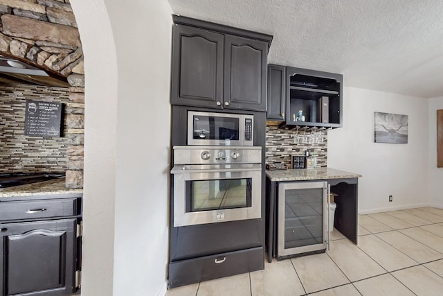 3008 Corona Dr NW, Albuquerque, NM 87120 - kitchen featuring backsplash, beverage cooler, light stone countertops, and appliances with stainless steel finishes