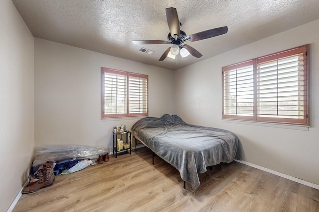 3008 Corona Dr NW, Albuquerque, NM 87120 - bedroom featuring a textured ceiling, a ceiling fan, baseboards, wood finished floors, and visible vents