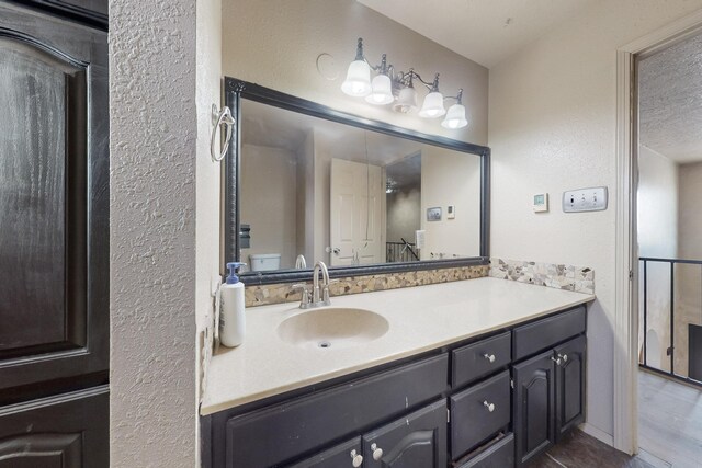 3008 Corona Dr NW, Albuquerque, NM 87120 - bathroom featuring vanity, a textured wall, toilet, and a textured ceiling