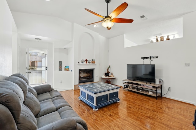 6901 Verano Ct NW, Albuquerque, NM 87120 - living area with lofted ceiling, a ceiling fan, light wood-style floors, a glass covered fireplace, and baseboards