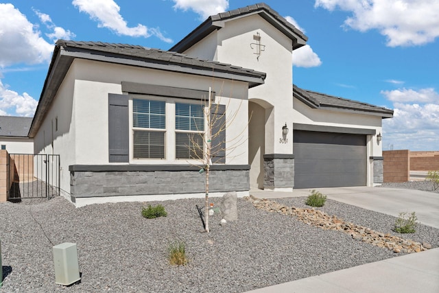 view of front of property featuring driveway, a tiled roof, fence, a garage, and stucco siding