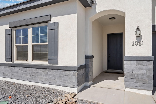 view of exterior entry with stucco siding