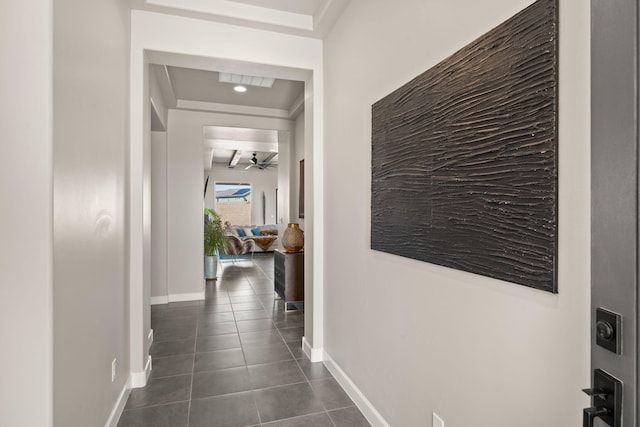 hall with dark tile patterned flooring and baseboards